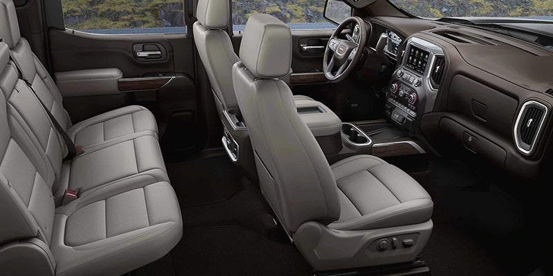 Interior view of a GMC Sierra 1500, showcasing the dashboard, seats, and modern technology features.