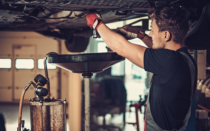 Service technician performing vehicle maintenance